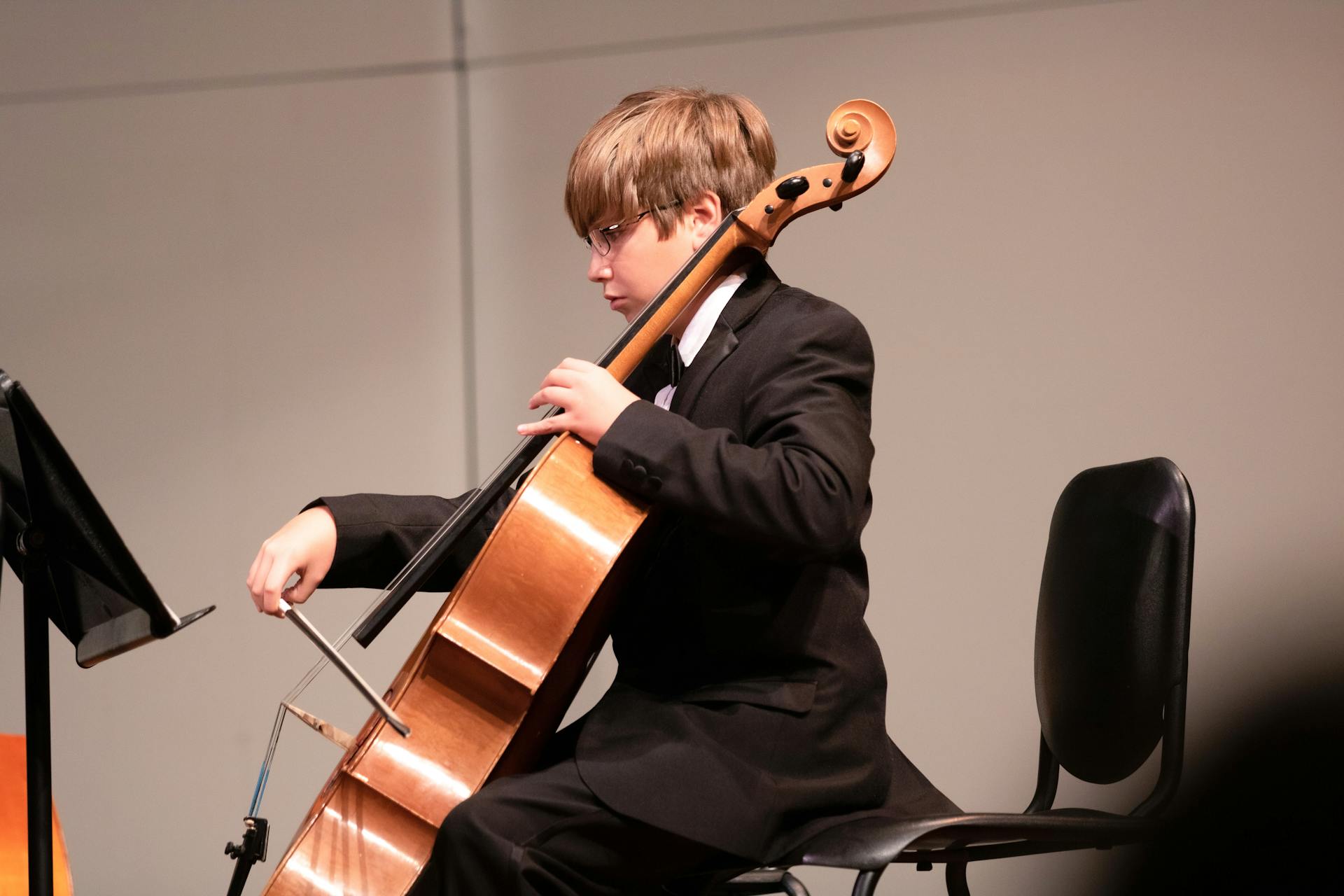 Boy playing cello during music lesson