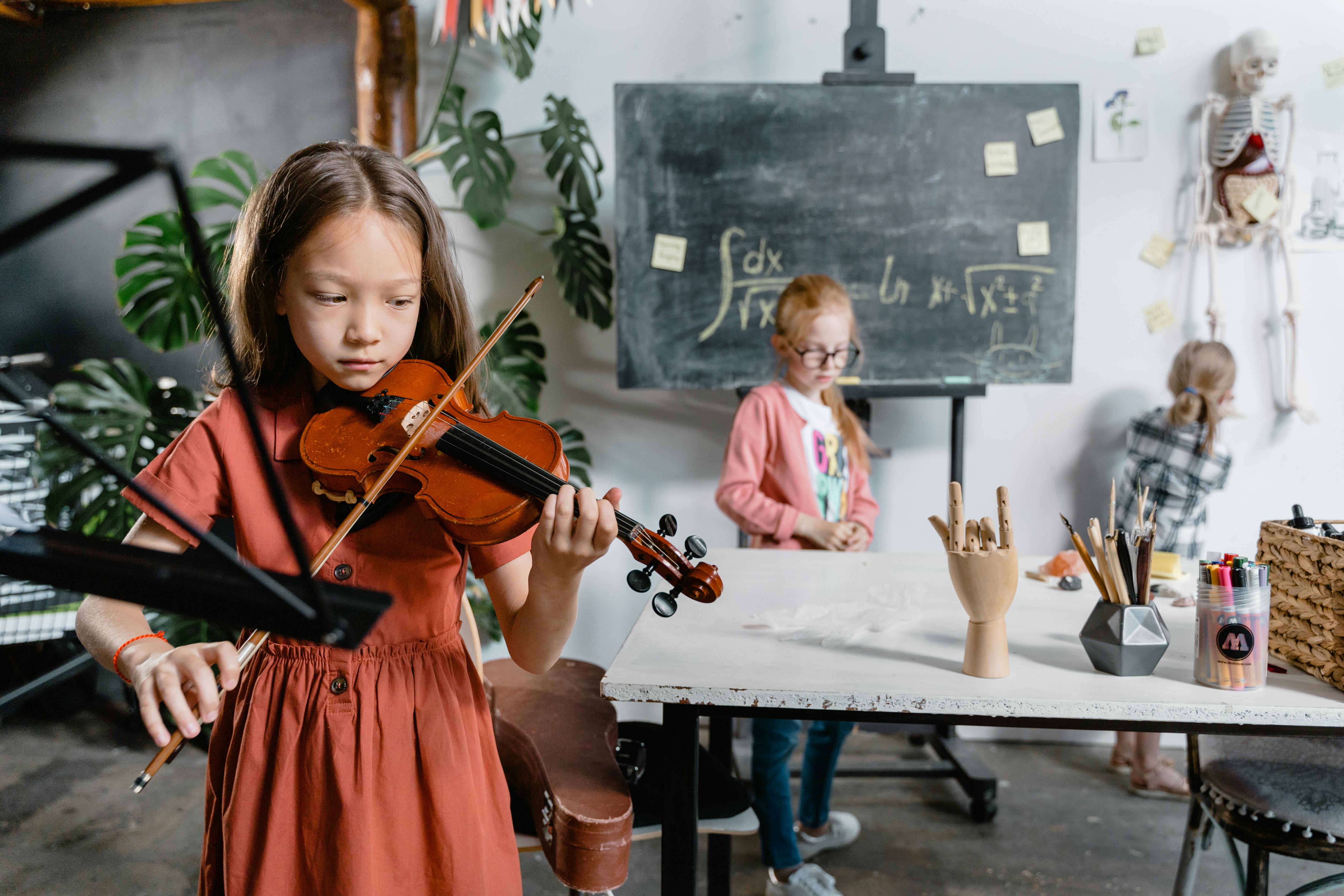 Young violin student practicing in a music classroom