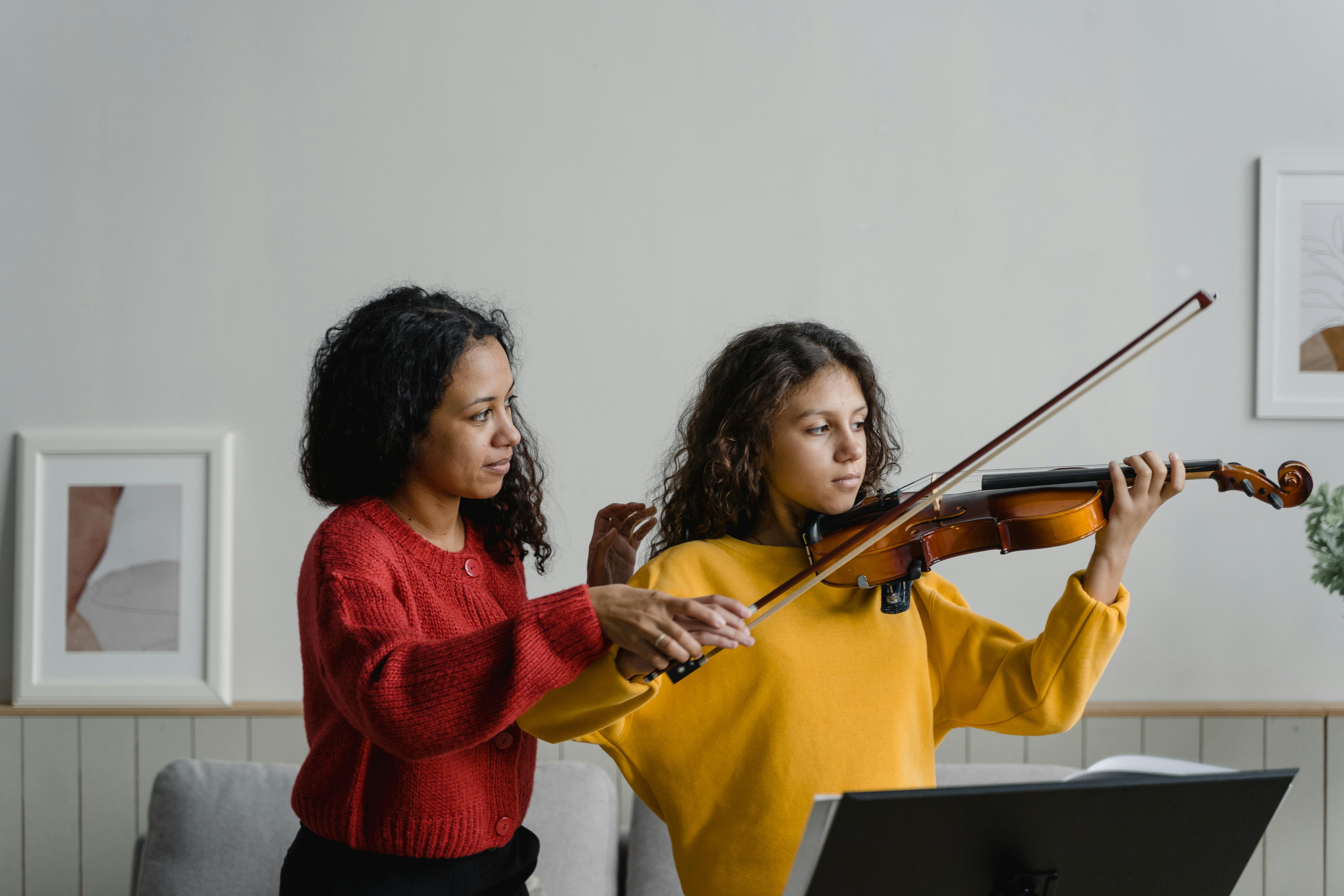Violin teacher guiding a young student during a private lesson
